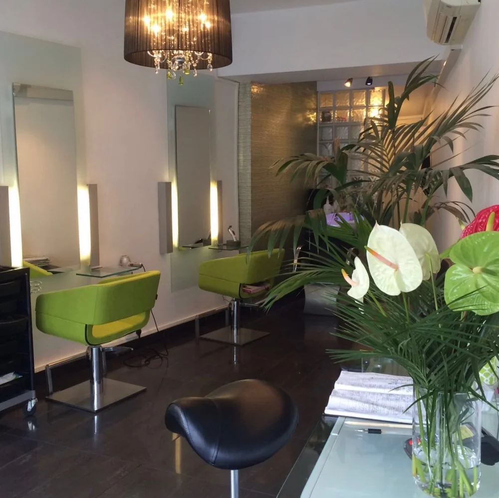 Inside Limelight Hair in Pontcanna, with fresh flowers and lime-green salon chairs